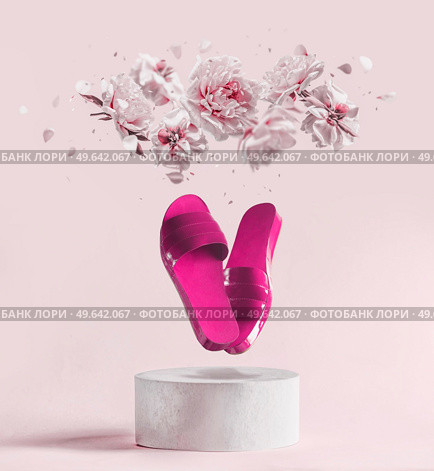 Pink flying flat sandal shoes at white podium with levitating peony flowers and petals at pink pastel background. Creative summer fashion concept with slippers and blossom. Modern product presentation. Стоковое фото, агентство Ingram Publishing / Фотобанк Лори