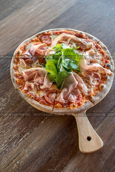 pizza parma ham and rocket salad on wooden table. Стоковое фото, агентство Ingram Publishing / Фотобанк Лори