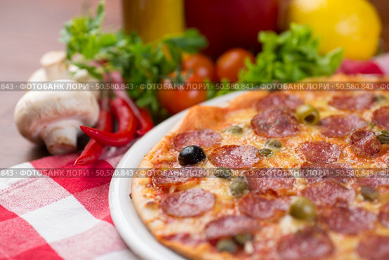 pizza with salamy sausages on picnic tablecloth. Стоковое фото, агентство Ingram Publishing / Фотобанк Лори