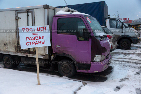Плакат "Рост цент = развал страны" стоит около протестного лагеря дальнобойщиков и магазина "Ашан" в пригороде Москвы, Россия (2015 год). Редакционное фото, фотограф Николай Винокуров / Фотобанк Лори