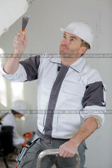 plasterer renovating indoor walls and ceilings with float and plaster. Стоковое фото, агентство Ingram Publishing / Фотобанк Лори
