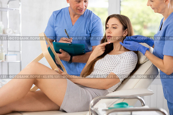 Plastic surgeon and nurse consulting young woman before facelift operation in clinic. Стоковое фото, фотограф Яков Филимонов / Фотобанк Лори