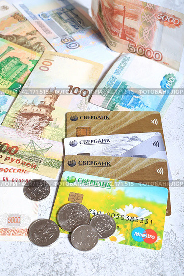 Пластиковые банковские карты сбербанка и российские рубли крупным планом (2024 год). Редакционное фото, фотограф Яна Королёва / Фотобанк Лори