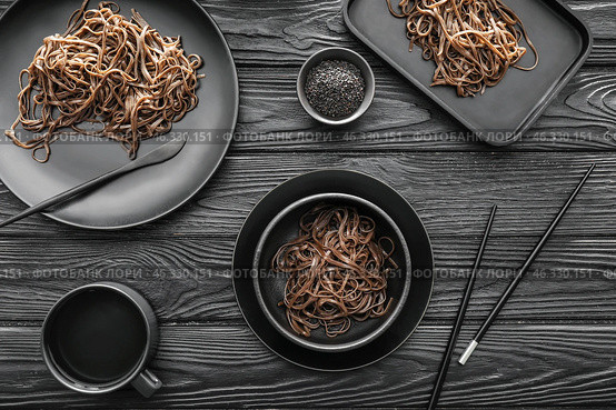 Plates with soba noodles on dark wooden background. Стоковое фото, фотограф Pixel_shot / Фотобанк Лори