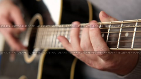 Playing the guitar. Strumming black acoustic guitar. Musician plays music. Man fingers holding mediator. Male hand playing guitar neck in dark room. Unrecognizable person rehearsing, fretboard closeup. Стоковое видео, видеограф Марина Демидюк / Фотобанк Лори