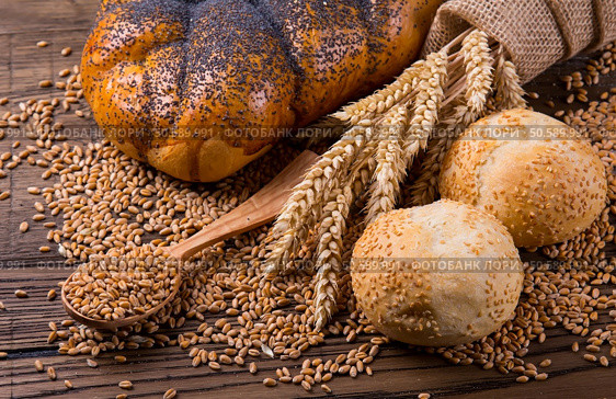 Plenty of sliced bread background. Bakery and grocery concept. Fresh, healthy whole grain sliced sorts of rye and white loaves, sprinkled flour on sackcloth and rustic wood table, food top view. Bakery concept. Plenty of sliced bread background. Стоковое фото, агентство Ingram Publishing / Фотобанк Лори