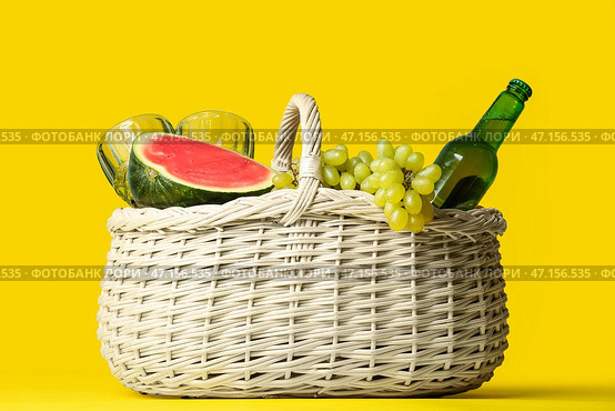 Плетеная корзина с вкусной едой и напитками для пикника на цветном фоне. Стоковое фото, фотограф Pixel_shot / Фотобанк Лори