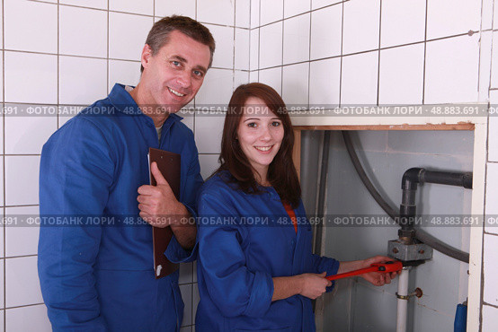 Plumber and female apprentice smiling. Стоковое фото, агентство Ingram Publishing / Фотобанк Лори
