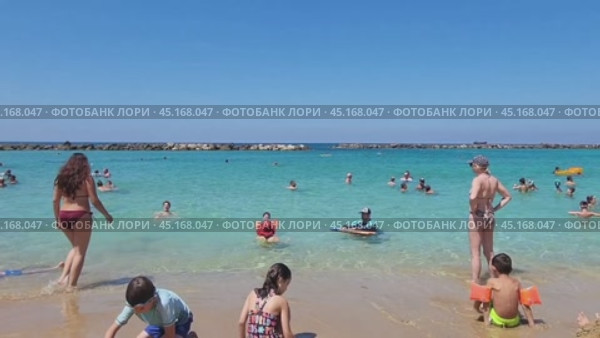 Пляж. Люди купаются в море, дети играют на песке (2024 год). Редакционное видео, видеограф Татьяна Бакуменко / Фотобанк Лори