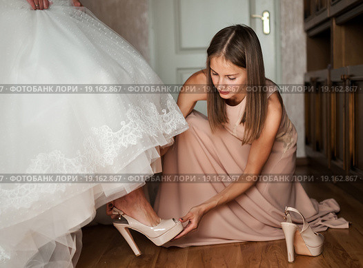 Подружка помогает одеть туфли невесте. Стоковое фото, фотограф Игорь Низов / Фотобанк Лори