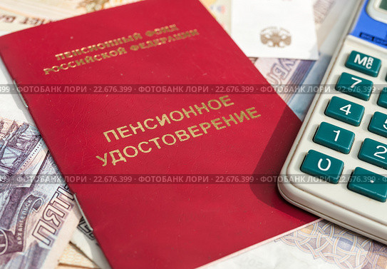 Подсчёт пенсии. Пенсионное удостоверение и калькулятор лежат на российских деньгах. Стоковое фото, фотограф Игорь Низов / Фотобанк Лори