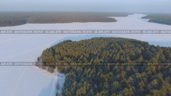 Полёт над зимним озером и лесом. Стоковое видео, видеограф Денис Логиновский / Фотобанк Лори