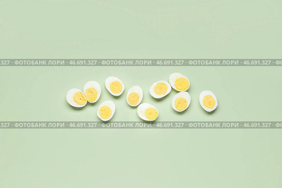 Половинки вкусных отваренных яиц на зеленом фоне. Стоковое фото, фотограф Pixel_shot / Фотобанк Лори