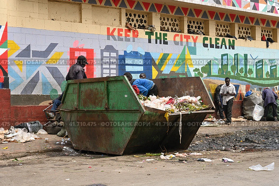 Poor people rummage through a container of food waste at the central market in Nairobi, Kenya (2022 год). Редакционное фото, фотограф Алексей Кузнецов / Фотобанк Лори