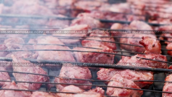 Pork Butt sliced on BBQ. Shish kebab. Pieces of pork on the grid, grilled meat with smoke. Food preparation process. Marinated spiced fillet meat cooked on charcoal barbeque grill. Outdoors cooking. Стоковое видео, видеограф Марина Демидюк / Фотобанк Лори