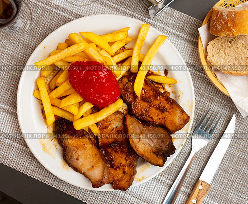 Pork loin with fried potato and pimiento on plate. Стоковое фото, фотограф Яков Филимонов / Фотобанк Лори