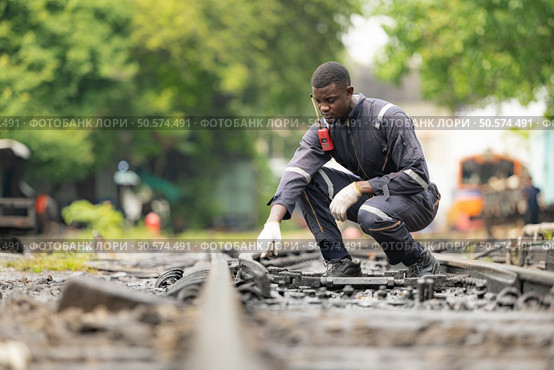 Portrait of a railway engineer on the tracks of a train in station platform. Стоковое фото, агентство Ingram Publishing / Фотобанк Лори