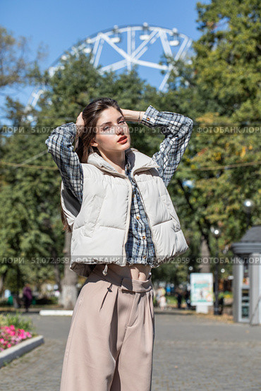 Portrait of a young beautiful girl in a checkered shirt and beige pants. Стоковое фото, фотограф Андрей Аркуша / Фотобанк Лори