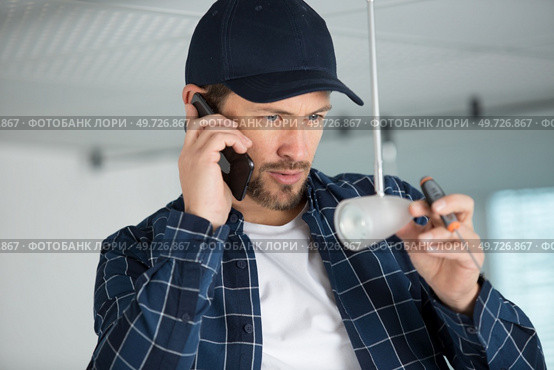 portrait of an artisan talking on the phone. Стоковое фото, агентство Ingram Publishing / Фотобанк Лори