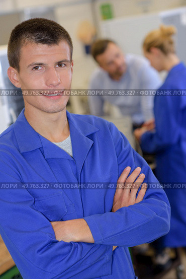 portrait of apprentice engineer posing crossing arms in laboratory. Стоковое фото, агентство Ingram Publishing / Фотобанк Лори