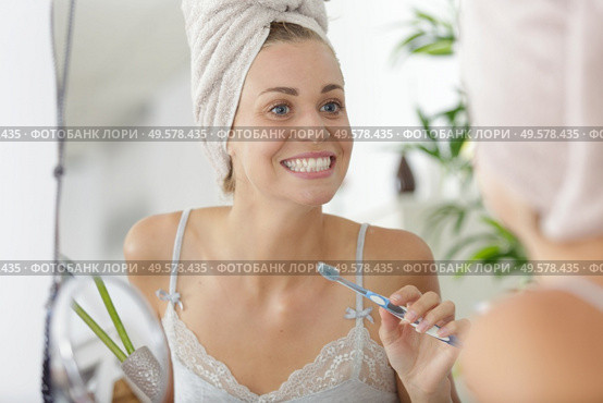 portrait of beautiful young woman brushing teeth. Стоковое фото, агентство Ingram Publishing / Фотобанк Лори