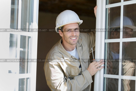 portrait of contractor working on double glazed windows. Стоковое фото, агентство Ingram Publishing / Фотобанк Лори