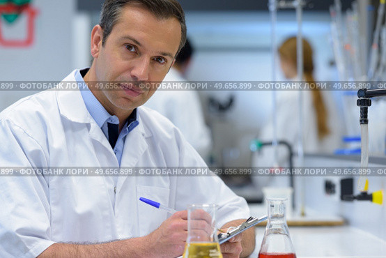 portrait of doctor documenting scientific experiment. Стоковое фото, агентство Ingram Publishing / Фотобанк Лори