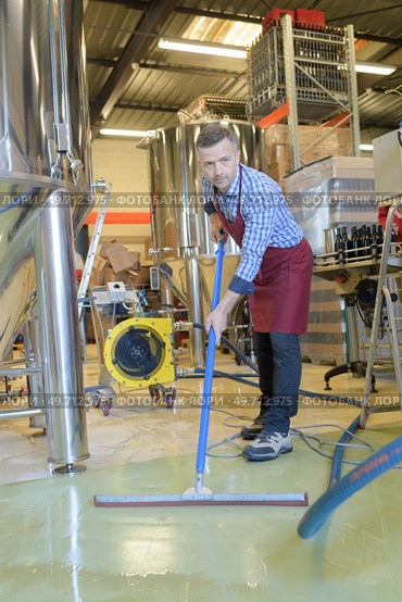 portrait of factory worker cleaning floor. Стоковое фото, агентство Ingram Publishing / Фотобанк Лори