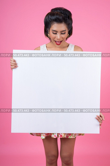 Portrait of fashion woman displaying white banner. Стоковое фото, агентство Ingram Publishing / Фотобанк Лори