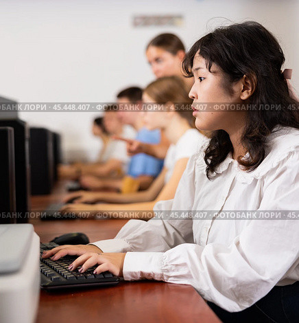 Portrait of fifteen-year-old schoolgirl studying at computer in class at an informatics lesson with classmates. Стоковое фото, фотограф Яков Филимонов / Фотобанк Лори