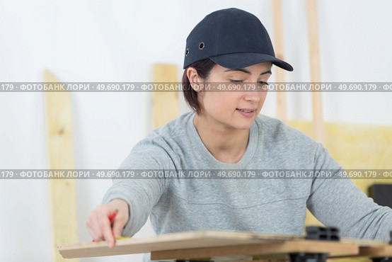 portrait of happy female woodworker drafting new project at workshop. Стоковое фото, агентство Ingram Publishing / Фотобанк Лори