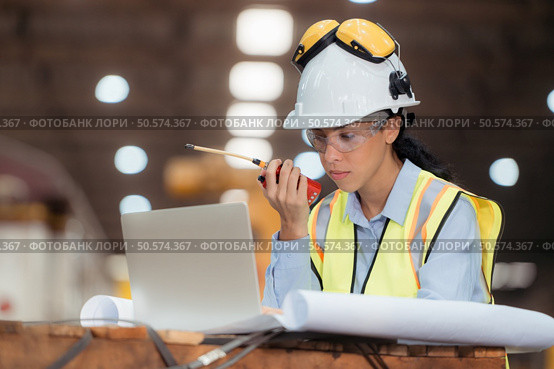 Portrait of railway technician worker in safety vest and helmet working with blueprint at train repair station. Стоковое фото, агентство Ingram Publishing / Фотобанк Лори