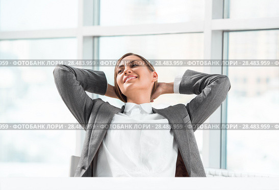 Portrait of smiling young business woman relaxing at office. Стоковое фото, фотограф Kirill Kedrinskiy / Ingram Publishing / Фотобанк Лори