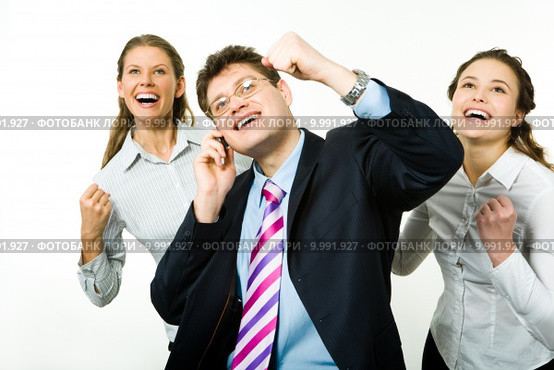 Portrait of three business partners holding their arms up and looking upwards with businessman speaking on the phone. Стоковое фото, фотограф Dmitriy Shironosov / PantherMedia / Фотобанк Лори