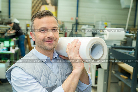 portrait of warehouse worker carrying paper. Стоковое фото, агентство Ingram Publishing / Фотобанк Лори