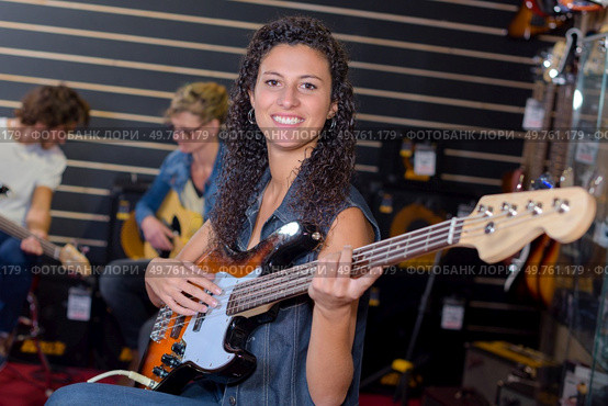 Portrait of woman strumming guitar. Стоковое фото, агентство Ingram Publishing / Фотобанк Лори