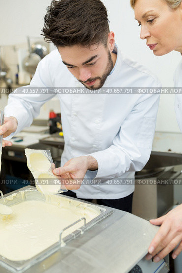 portrait of workers putting chocolate in mold. Стоковое фото, агентство Ingram Publishing / Фотобанк Лори