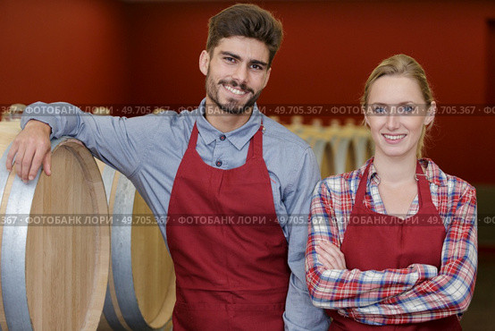 portrait of young couple in cellar with oak barrels. Стоковое фото, агентство Ingram Publishing / Фотобанк Лори