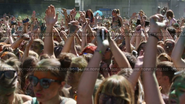 Посетители музыкального фестивале индийских красок ColorFest бросают друг в друга сухой краской в Москве на проспекте Сахарова 13 июля 2014 (2015 год). Редакционное видео, видеограф Николай Винокуров / Фотобанк Лори
