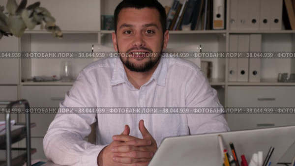 Positive man office worker sitting at table and gesturing. Стоковое видео, видеограф Яков Филимонов / Фотобанк Лори