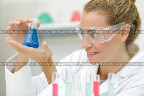 positive minded woman smiling while looking at a test tube. Стоковое фото, агентство Ingram Publishing / Фотобанк Лори