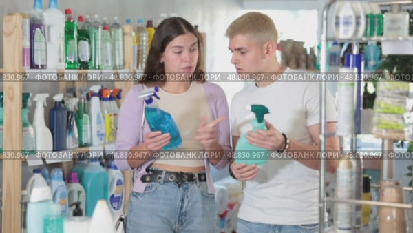 Positive young couple choosing convenient cleaning spray in household goods shop. Стоковое видео, видеограф Яков Филимонов / Фотобанк Лори