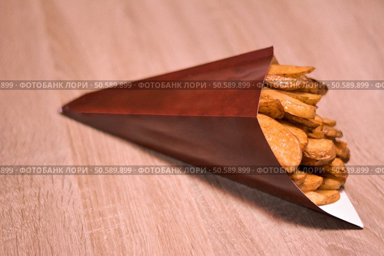 Potatoes wedges in paper cone. Стоковое фото, агентство Ingram Publishing / Фотобанк Лори