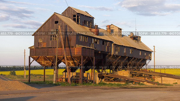 Поволжье, страда. Механизированный ток на закате. Volga region, harvest season. Mechanized threshing floor at the sunset light. (2022 год). Редакционное фото, фотограф Евгений Романов / Фотобанк Лори