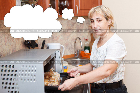 Пожилая домохозяйка готовит в микроволновке курицу в пакете. Стоковое фото, фотограф Кекяляйнен Андрей / Фотобанк Лори