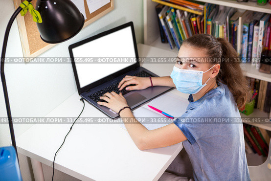 Pre-teen Caucasian girl doing school exercises online using webcasting, distance education during covid-19 pandemic. Стоковое фото, фотограф Кекяляйнен Андрей / Фотобанк Лори
