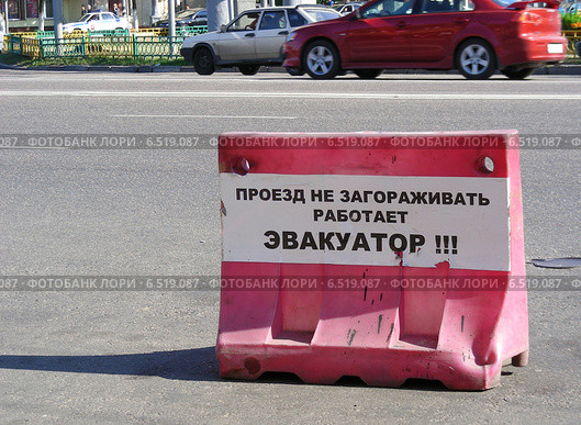 Предупреждающая табличка "Проезд не загораживать, работает эвакуатор!". Заграждение на улице Сергия Радонежского, Москва (2009 год). Стоковое фото, фотограф lana1501 / Фотобанк Лори