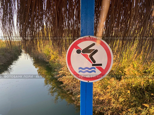 Предупреждающий знак прыгать в реку с моста запрещено. A warning sign warning that jumping into the river from the bridge is forbidden. Стоковое фото, фотограф Ольга Петрова-Апостолова / Фотобанк Лори