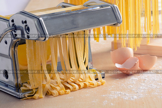 Preparation of homemade pasta spaghetti  on wooden background. Стоковое фото, агентство Ingram Publishing / Фотобанк Лори