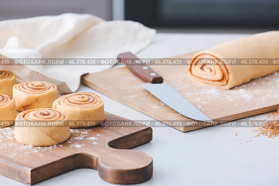 Preparing of tasty cinnamon rolls in kitchen. Стоковое фото, фотограф Pixel_shot / Фотобанк Лори